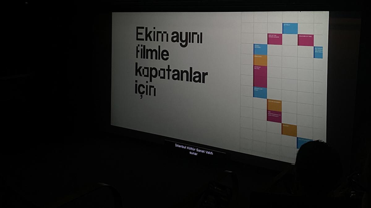 sinema perdesinde "ekim ayını filmle kapatanlar için" sloganı görünen fotoğraf
