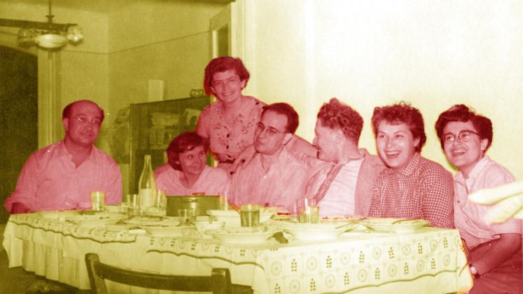 bir masa başında toplanmış kişilerin fotoğrafı, aralarında Açıkgöz çifti ve Nazım Hikmet de var.