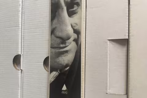 evrak kutularının fotoğrafı, bir kutunun sırtında yazarın fotoğrafı yapışık